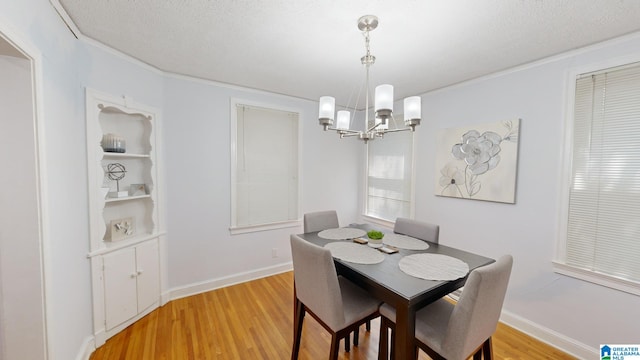 dining room with a textured ceiling, light hardwood / wood-style flooring, and a chandelier