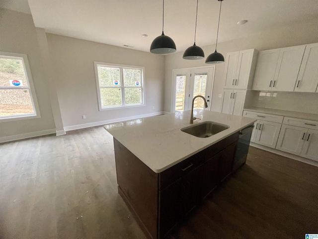 kitchen with pendant lighting, stainless steel dishwasher, sink, white cabinets, and dark hardwood / wood-style flooring