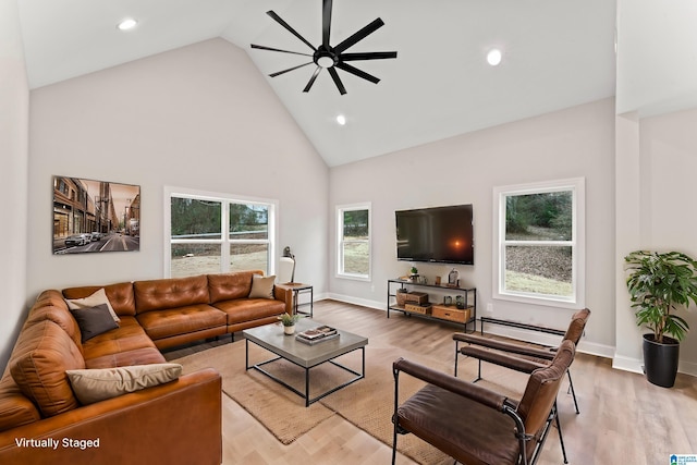 living room featuring baseboard heating, high vaulted ceiling, a ceiling fan, and wood finished floors