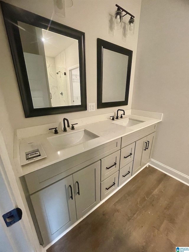 bathroom featuring walk in shower, vanity, and wood-type flooring