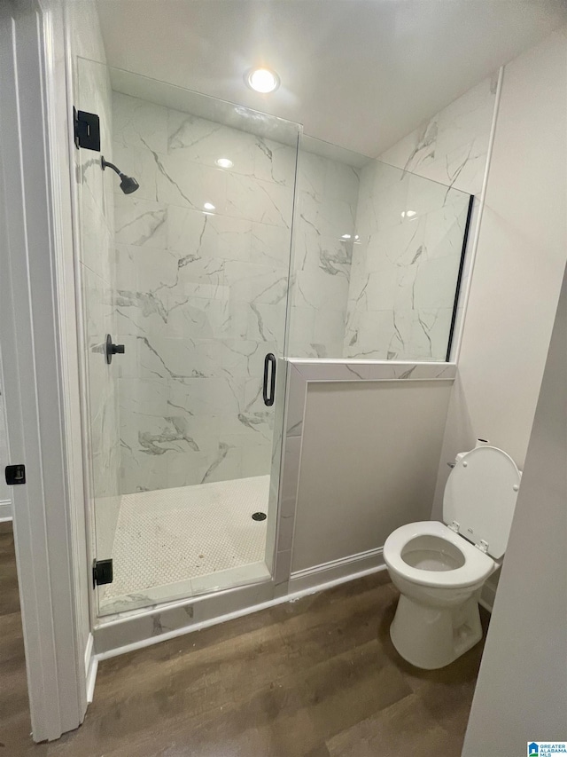 bathroom with toilet, hardwood / wood-style flooring, and an enclosed shower