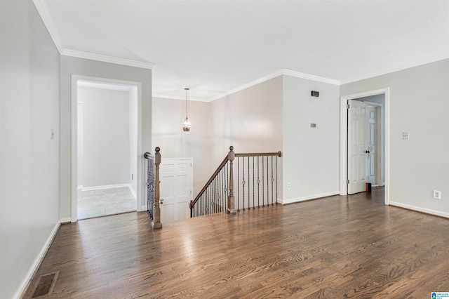 spare room featuring crown molding and dark hardwood / wood-style flooring