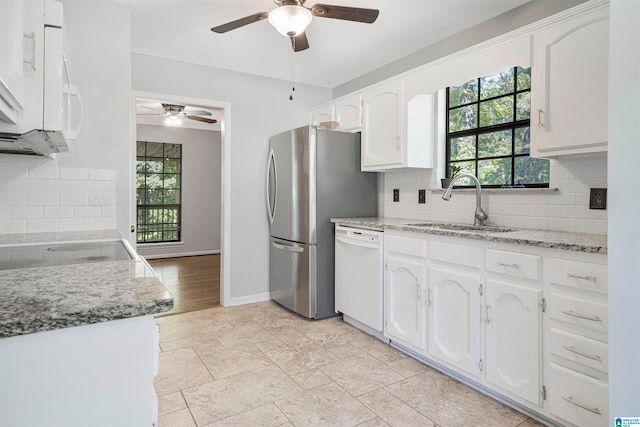 kitchen featuring a healthy amount of sunlight, white cabinets, and white appliances