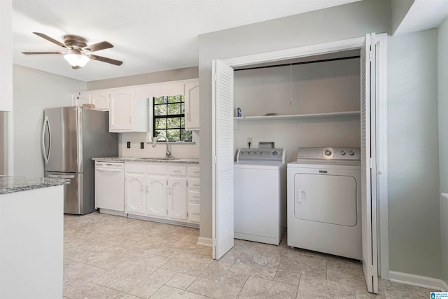 clothes washing area featuring washer and dryer, sink, and ceiling fan