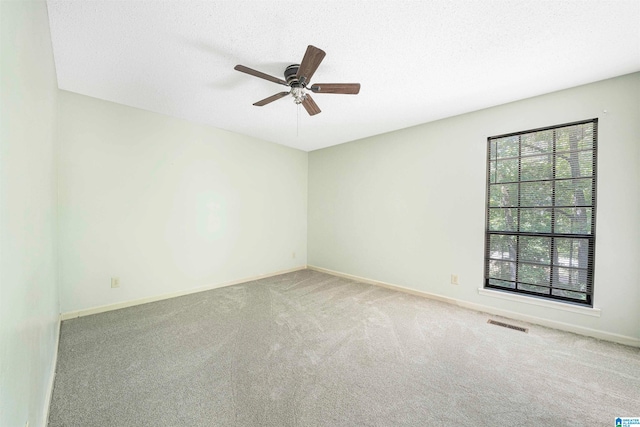 carpeted empty room with a textured ceiling and ceiling fan