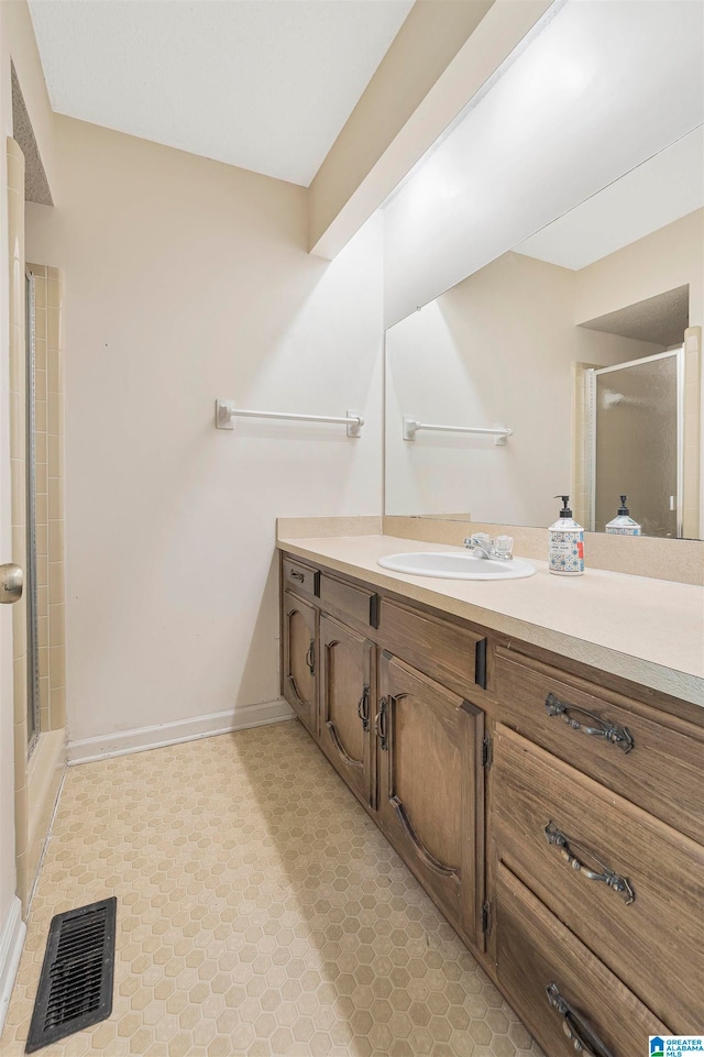 bathroom featuring vanity and a shower with door