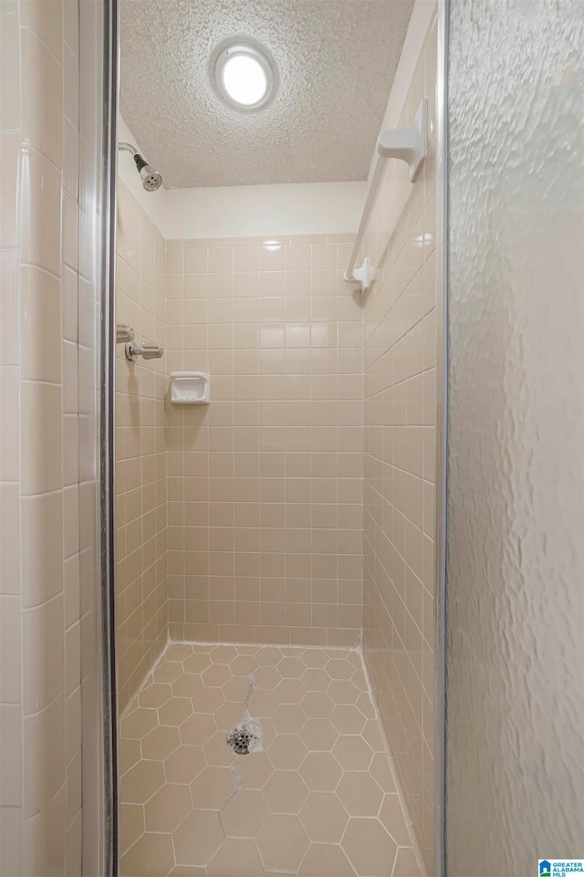 bathroom with tile patterned floors, a textured ceiling, and an enclosed shower