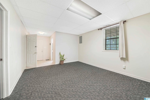 carpeted empty room with a drop ceiling