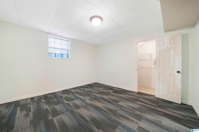 interior space with a drop ceiling and dark wood-type flooring