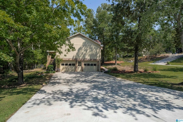 view of side of property featuring a garage and a lawn