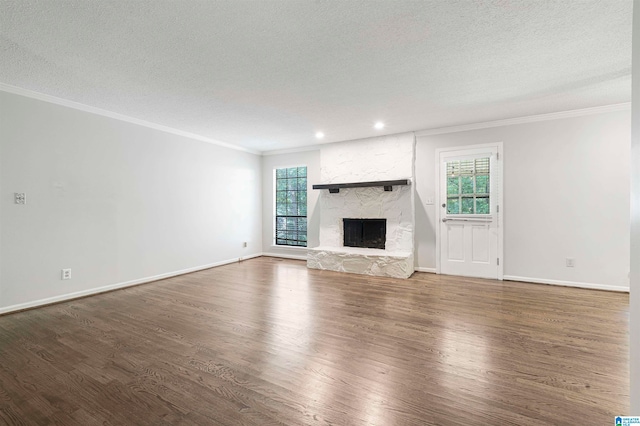 unfurnished living room with a textured ceiling, dark hardwood / wood-style flooring, and plenty of natural light