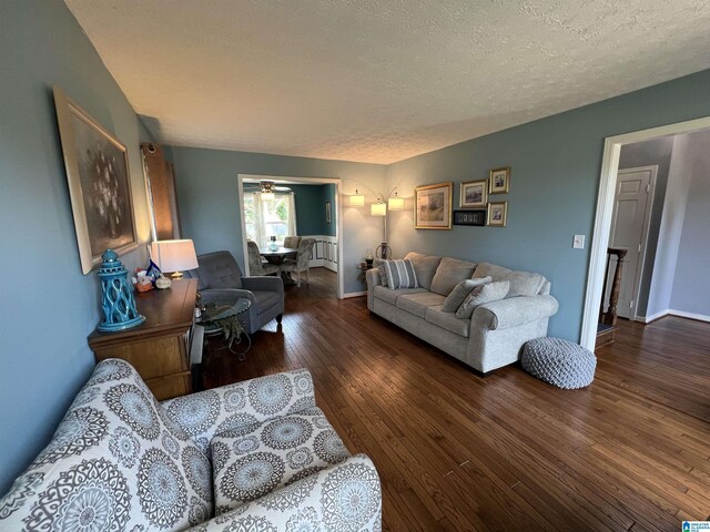 living room featuring dark hardwood / wood-style flooring and a textured ceiling