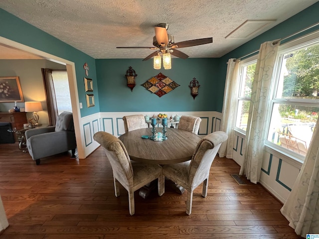 dining space with ceiling fan, dark hardwood / wood-style floors, and a textured ceiling