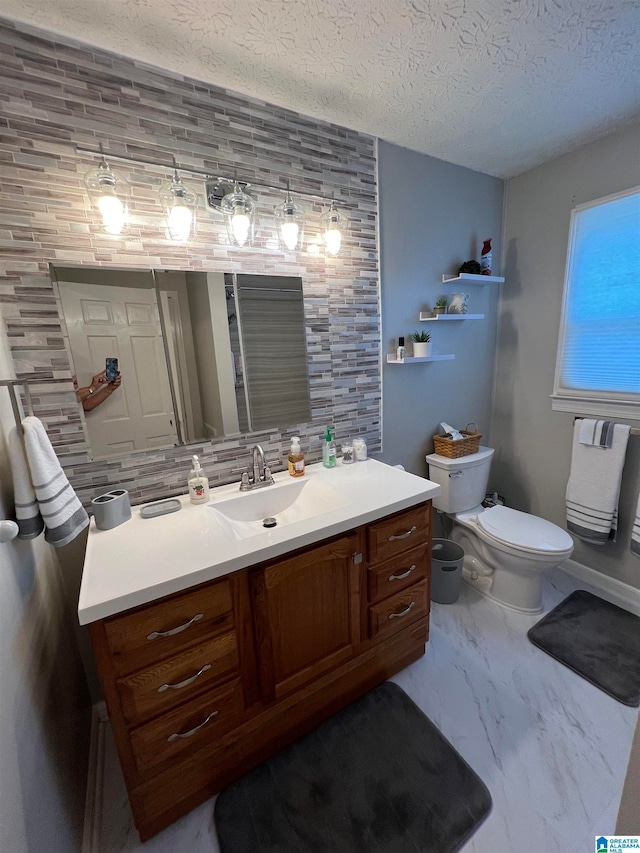 bathroom featuring a textured ceiling, vanity, toilet, and decorative backsplash