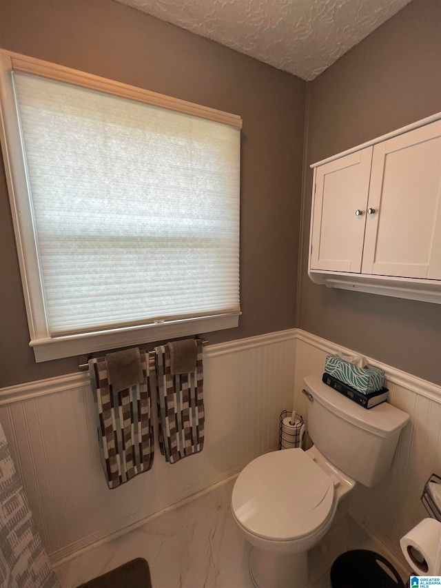 bathroom with a textured ceiling and toilet