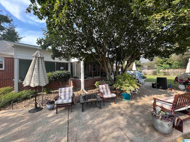 view of patio / terrace with a sunroom and an outdoor fire pit