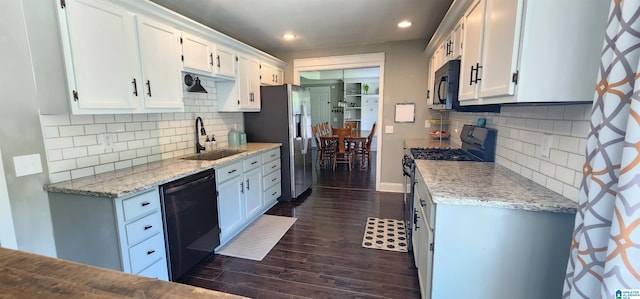 kitchen featuring black appliances, white cabinetry, and sink