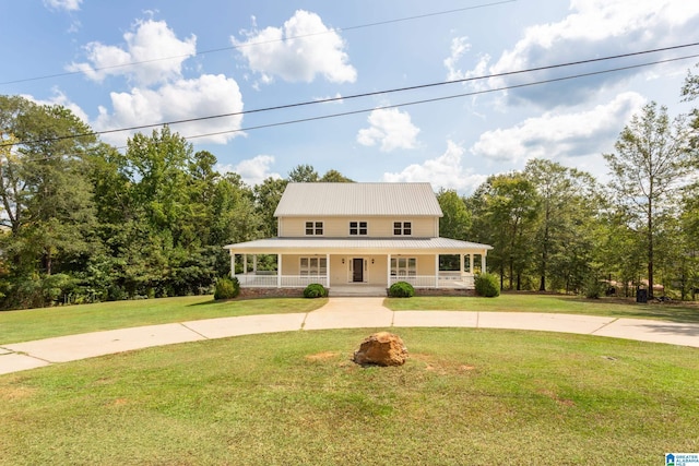 farmhouse inspired home with a porch, metal roof, a front yard, and curved driveway