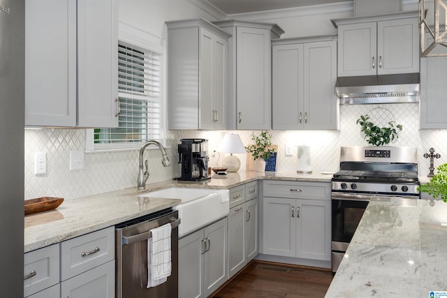 kitchen with stainless steel appliances, exhaust hood, sink, and light stone countertops