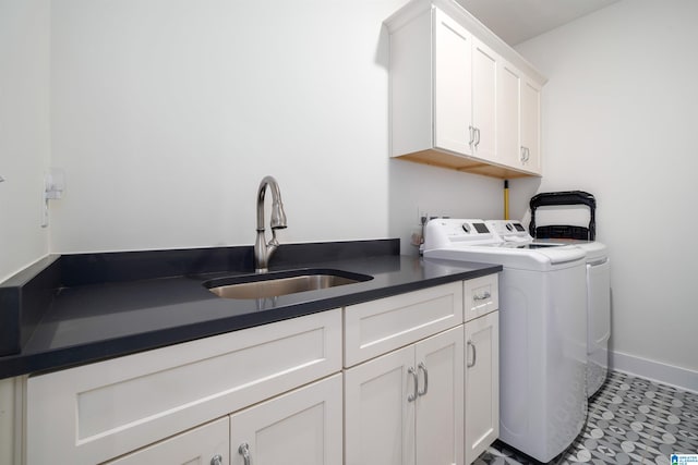 clothes washing area with cabinets, sink, and washing machine and dryer