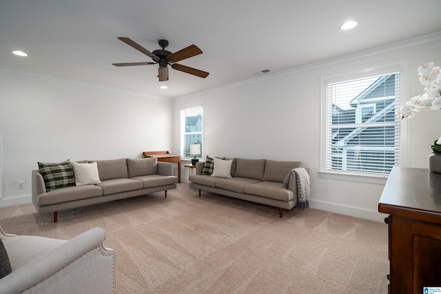 living room featuring ceiling fan, a wealth of natural light, light carpet, and ornamental molding