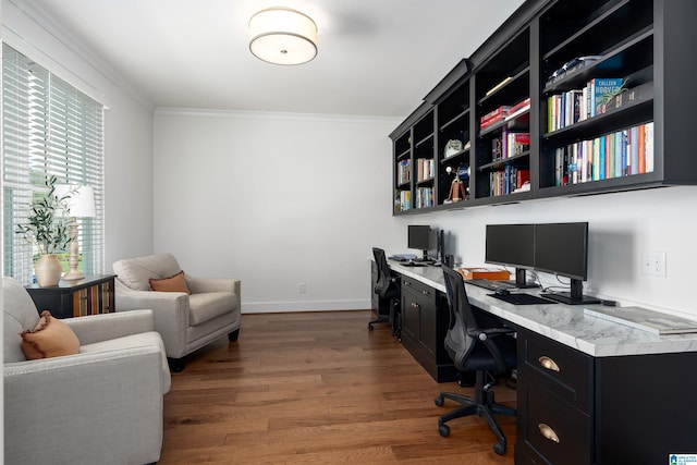 office area featuring crown molding, dark wood-type flooring, and built in desk