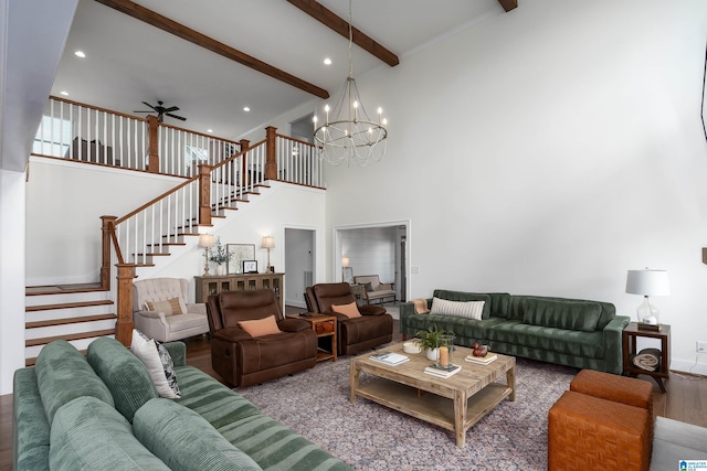 living room featuring ceiling fan with notable chandelier, a towering ceiling, hardwood / wood-style floors, and beam ceiling