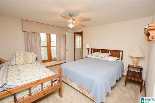 bedroom featuring light carpet, a textured ceiling, and ceiling fan