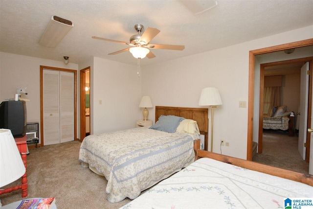 carpeted bedroom featuring a textured ceiling and ceiling fan