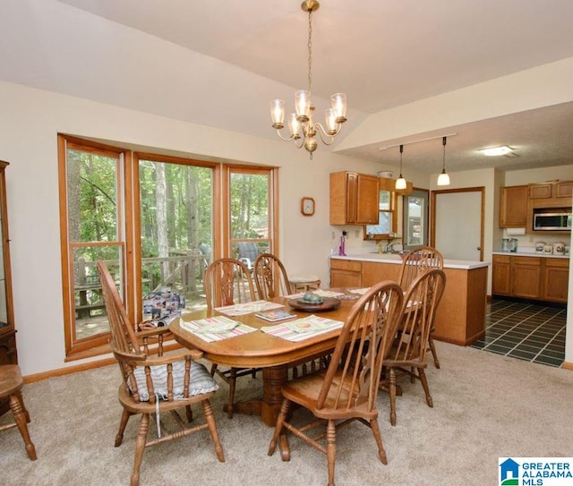 dining area with lofted ceiling, plenty of natural light, carpet floors, and a chandelier