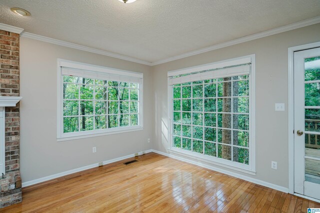 3424 Oakdale Dr, Vestavia Hills, AL 35223 - empty room with a textured ceiling, light wood-style flooring, visible vents, and ornamental molding