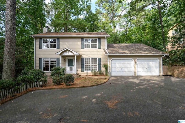 3424 Oakdale Dr, Vestavia Hills, AL 35223 - colonial inspired home featuring aphalt driveway, a chimney, a garage, and fence