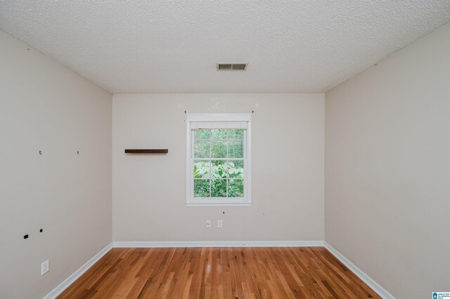 unfurnished room featuring a textured ceiling and wood-type flooring