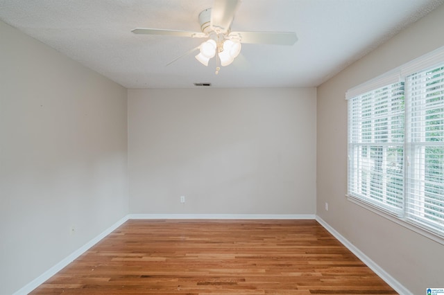 unfurnished room featuring ceiling fan, wood-type flooring, and a textured ceiling