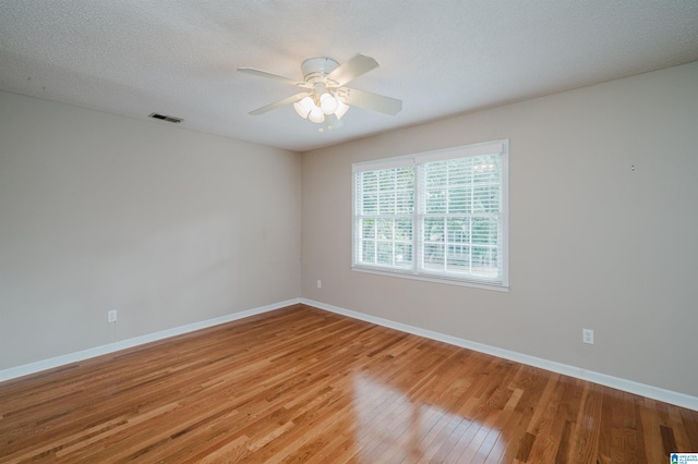 spare room featuring hardwood / wood-style floors, ceiling fan, and a textured ceiling