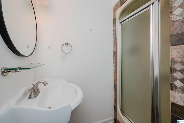 bathroom featuring an enclosed shower and sink