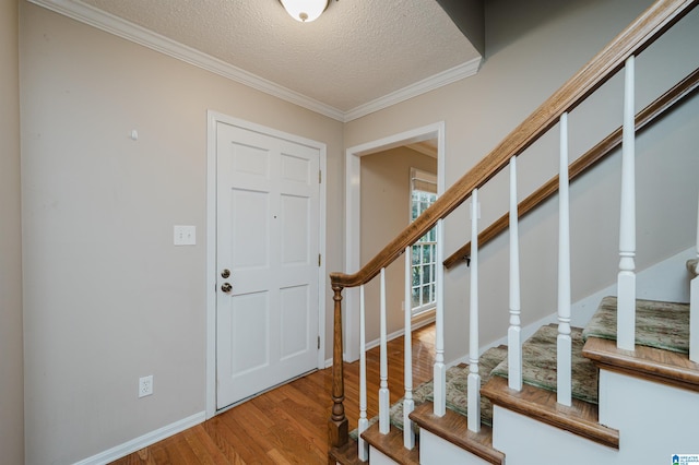 foyer with a textured ceiling, crown molding, and hardwood / wood-style flooring