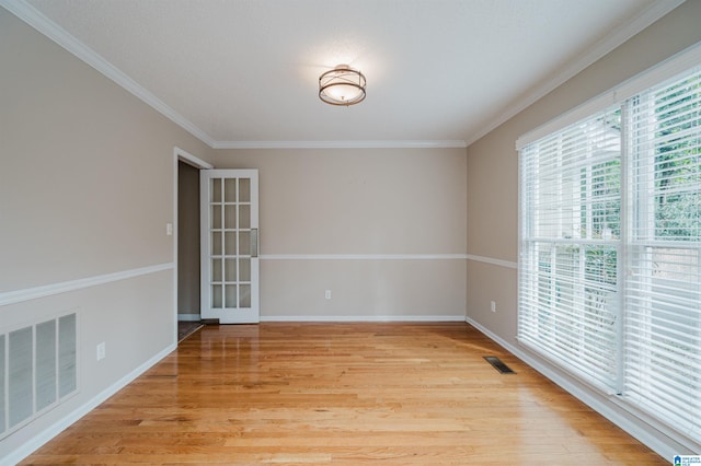 spare room with light wood-type flooring and ornamental molding