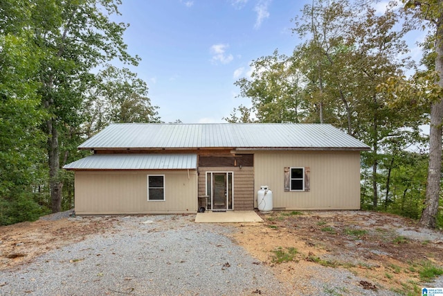 rear view of property with ceiling fan and a patio area