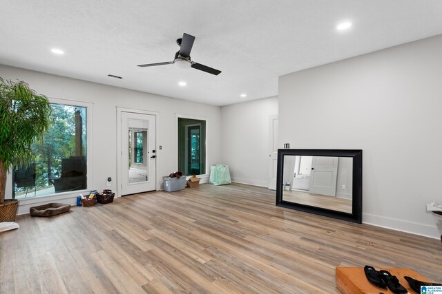 unfurnished living room with ceiling fan and hardwood / wood-style flooring