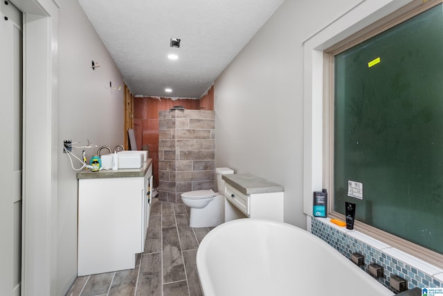 full bathroom featuring a textured ceiling, vanity, shower with separate bathtub, toilet, and hardwood / wood-style flooring