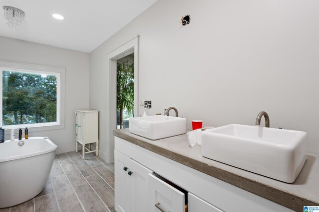 bathroom featuring vanity, a bathtub, and wood-type flooring