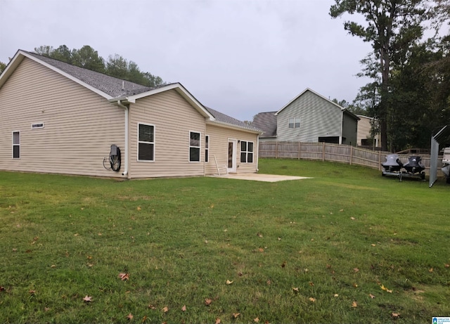 back of house featuring a lawn and a patio area