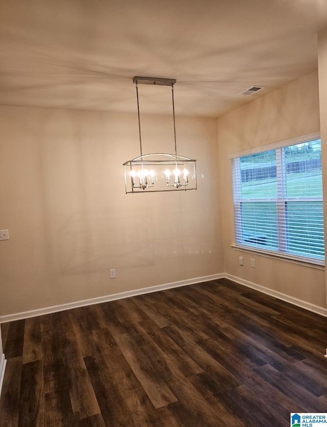 unfurnished dining area with a chandelier and dark wood-type flooring