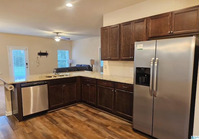 kitchen with kitchen peninsula, dark hardwood / wood-style flooring, ceiling fan, and stainless steel appliances