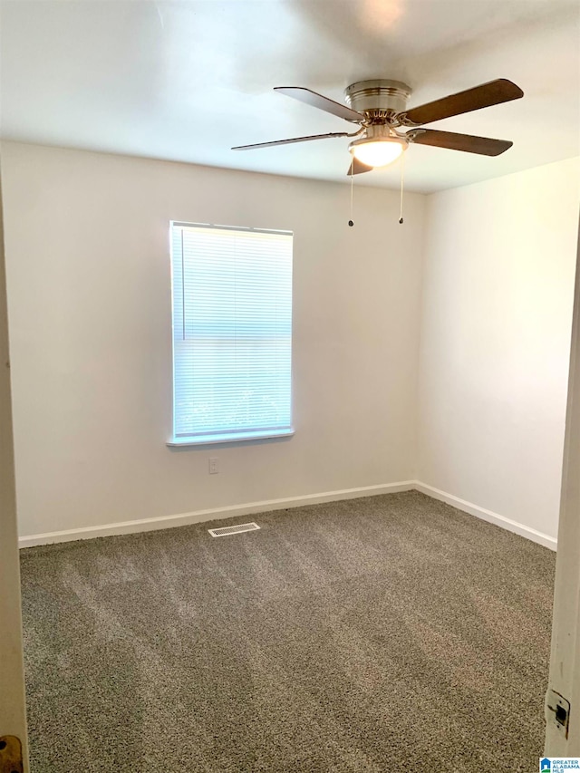 carpeted spare room featuring ceiling fan