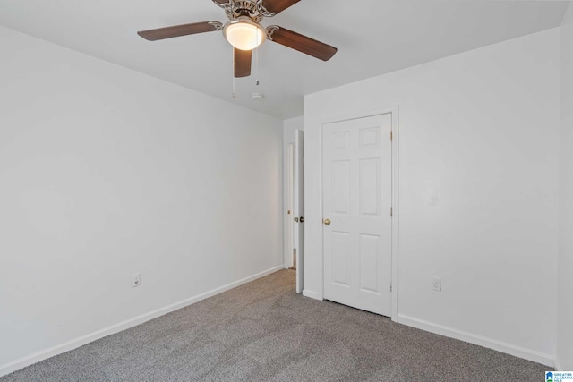 unfurnished room featuring ceiling fan and carpet