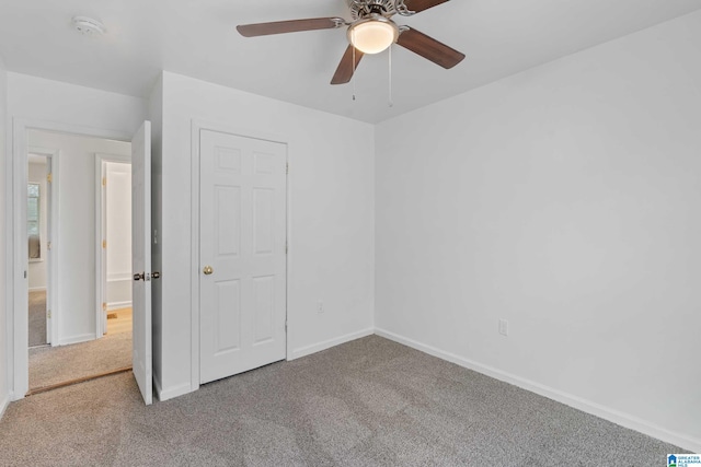 unfurnished bedroom featuring carpet floors, ceiling fan, and a closet