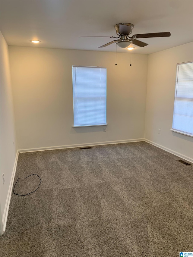 carpeted spare room with ceiling fan