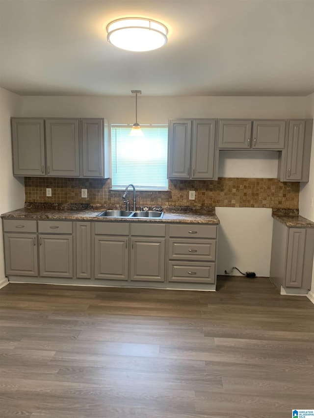 kitchen featuring hardwood / wood-style flooring, gray cabinetry, sink, and decorative light fixtures